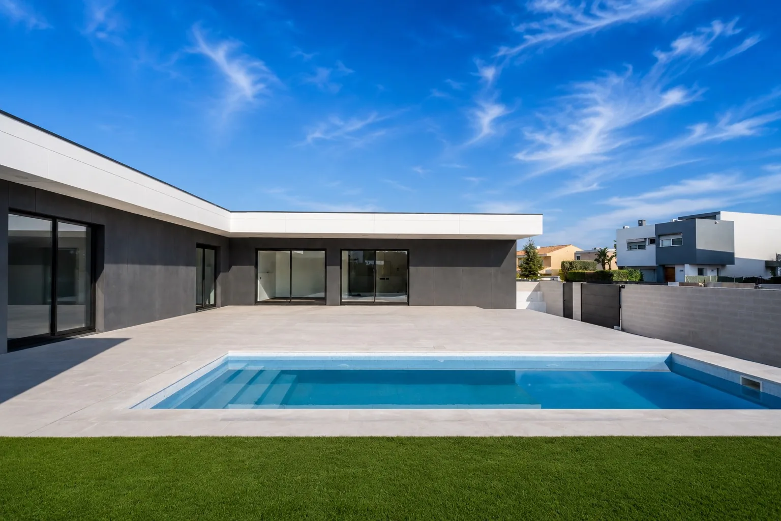 Piscina y terraza de gres de la Homi II con grandes correderas negras